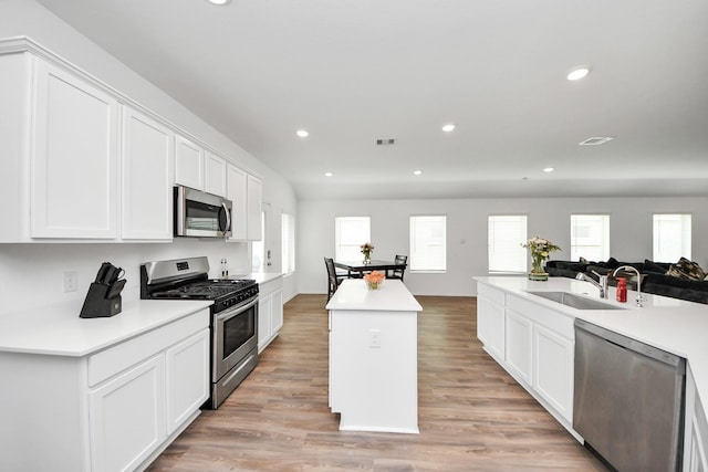 4710 Jasmine Heather Ln, Baytown, TX 77521 - kitchen featuring appliances with stainless steel finishes, a sink, recessed lighting, a center island, and white cabinetry