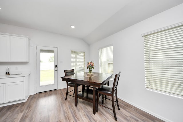 4710 Jasmine Heather Ln, Baytown, TX 77521 - dining room with healthy amount of natural light, light wood-type flooring, vaulted ceiling, and baseboards