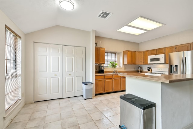 6511 Coldstream Dr, Pasadena, TX 77505 - kitchen with white microwave, stainless steel fridge, range, light countertops, and light tile patterned flooring