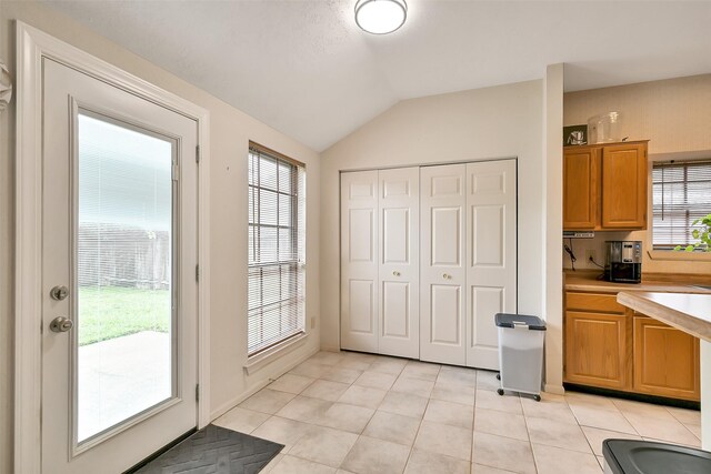 6511 Coldstream Dr, Pasadena, TX 77505 - doorway featuring light tile patterned floors, lofted ceiling, and healthy amount of natural light