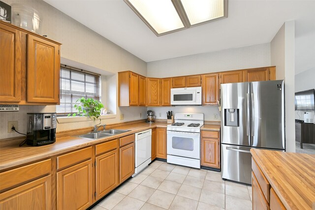 6511 Coldstream Dr, Pasadena, TX 77505 - kitchen with white appliances, a sink, butcher block counters, light tile patterned floors, and brown cabinets