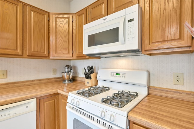 6511 Coldstream Dr, Pasadena, TX 77505 - kitchen with white appliances, wallpapered walls, and butcher block countertops