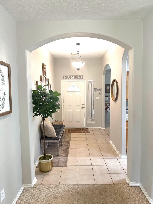 7126 Leens Lodge Ln, Humble, TX 77346 - foyer with arched walkways, light tile patterned floors, and baseboards