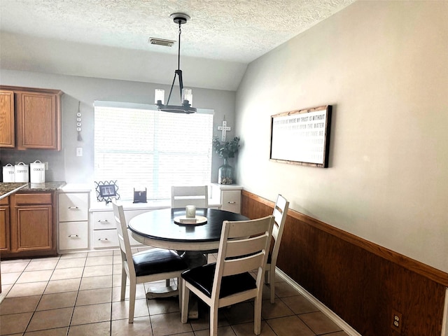 7126 Leens Lodge Ln, Humble, TX 77346 - dining space featuring lofted ceiling, a textured ceiling, light tile patterned floors, and a chandelier