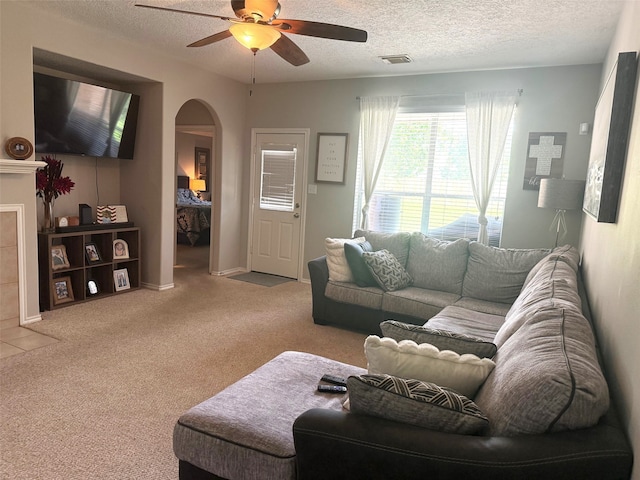 7126 Leens Lodge Ln, Humble, TX 77346 - living area featuring arched walkways, a ceiling fan, carpet, and a textured ceiling