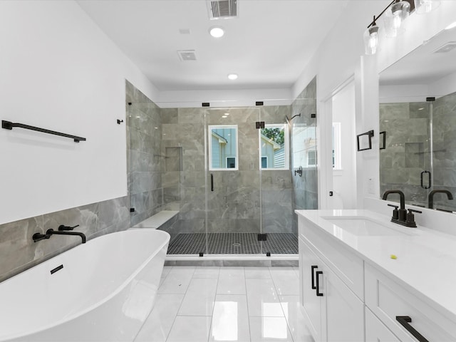 867 Mansfield St Unit E, Houston, TX 77091 - bathroom featuring a freestanding tub, vanity, a shower stall, and tile patterned flooring