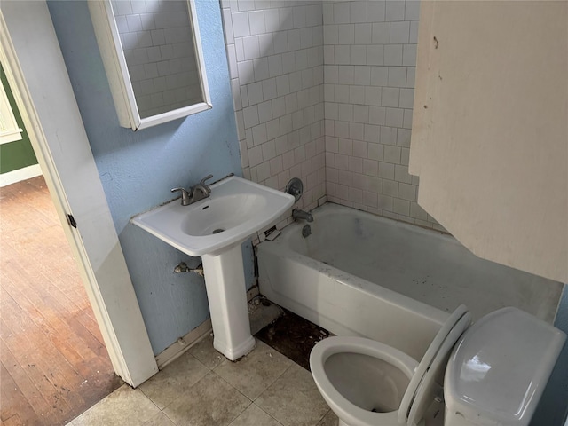 9434 E Ave K, Houston, TX 77012 - bathroom with toilet, shower / tub combination, baseboards, and tile patterned floors