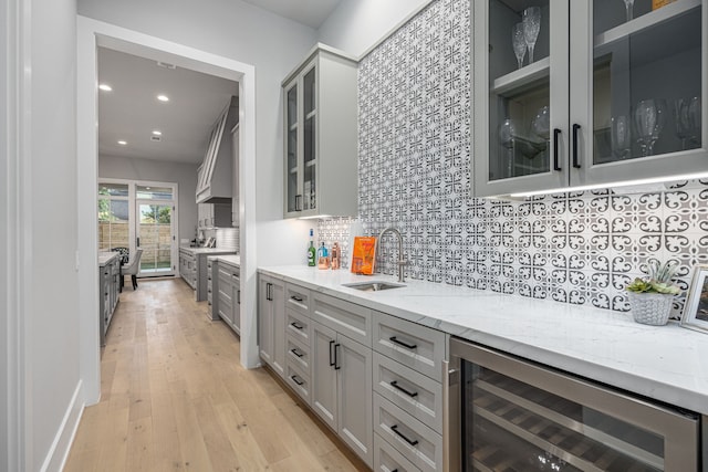 1710 Ebony Ln, Houston, TX 77018 - kitchen with a sink, beverage cooler, backsplash, light stone counters, and gray cabinets