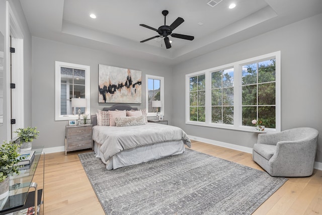 1710 Ebony Ln, Houston, TX 77018 - bedroom with a raised ceiling, light wood-style floors, multiple windows, baseboards, and recessed lighting