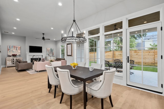 1710 Ebony Ln, Houston, TX 77018 - dining area featuring light wood-type flooring, a premium fireplace, recessed lighting, a ceiling fan, and a chandelier