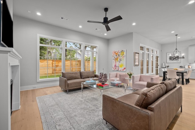 1710 Ebony Ln, Houston, TX 77018 - living room with ceiling fan, recessed lighting, a chandelier, a fireplace, and light wood finished floors
