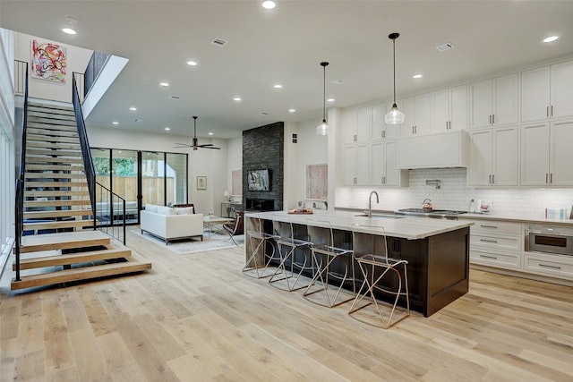 1710 Ebony Ln, Houston, TX 77018 - kitchen featuring a ceiling fan, custom exhaust hood, white cabinetry, a sink, and recessed lighting