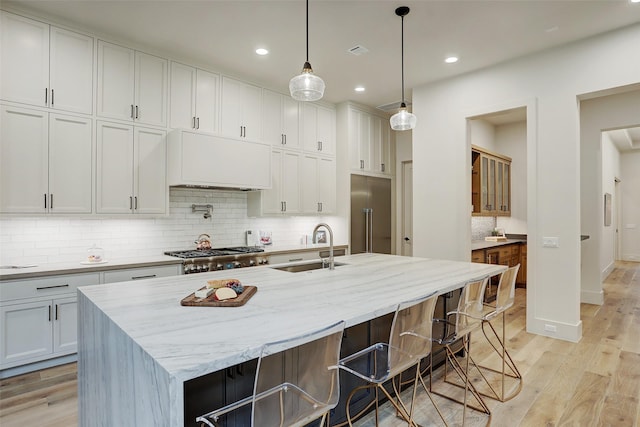 1710 Ebony Ln, Houston, TX 77018 - kitchen featuring a sink, light wood-type flooring, tasteful backsplash, recessed lighting, and light stone counters