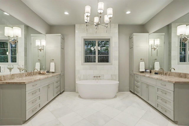 1710 Ebony Ln, Houston, TX 77018 - full bath featuring a freestanding bath, two vanities, recessed lighting, a chandelier, and marble look tile flooring