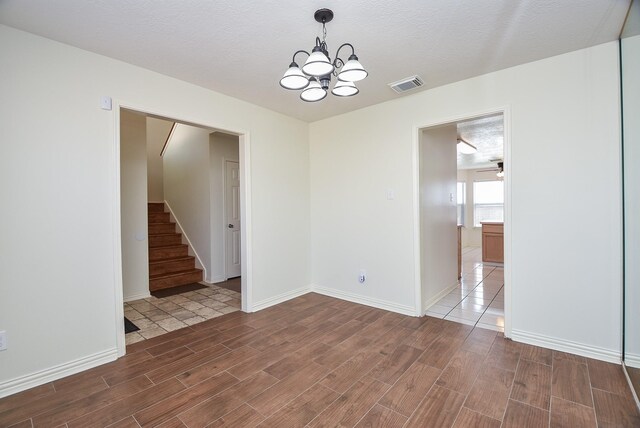 4026 Almond Lake Dr, Houston, TX 77047 - empty room featuring wood tiled floors, a chandelier, stairway, and baseboards