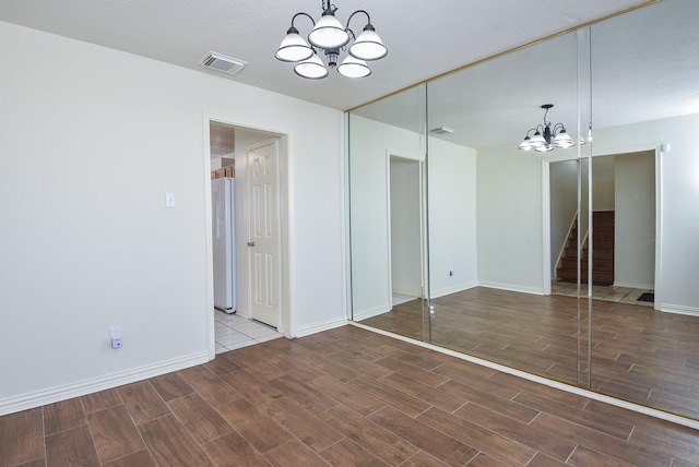 4026 Almond Lake Dr, Houston, TX 77047 - unfurnished bedroom with a chandelier, wood tiled floors, freestanding refrigerator, and baseboards