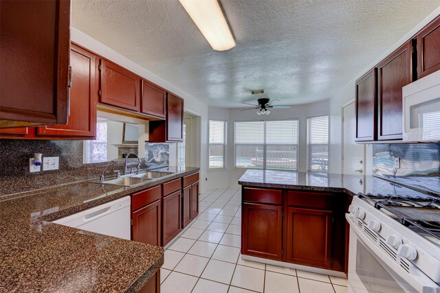 4026 Almond Lake Dr, Houston, TX 77047 - kitchen with white appliances, dark countertops, a peninsula, a sink, and a textured ceiling