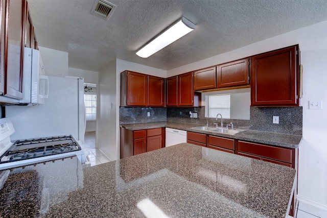 4026 Almond Lake Dr, Houston, TX 77047 - kitchen with a sink, white appliances, a textured ceiling, backsplash, and baseboards