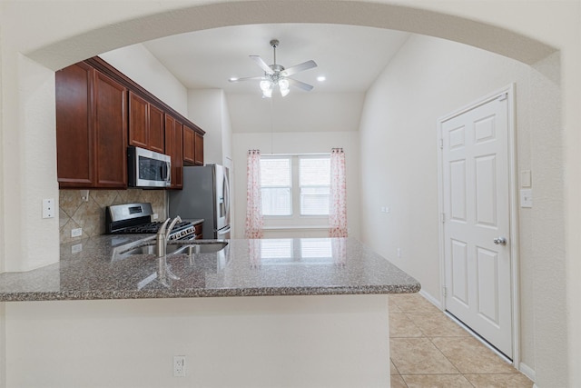 20210 Stonebridge Terrace Dr, Richmond, TX 77407 - kitchen with appliances with stainless steel finishes, a peninsula, a ceiling fan, dark stone countertops, and lofted ceiling