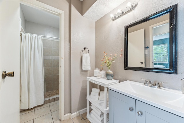 5707 Cripple Brook Ct, Houston, TX 77017 - bathroom with tile patterned floors, tiled shower, vanity, a textured wall, and baseboards