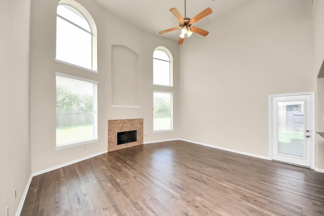 2304 Shadow Canyon Ct, Pearland, TX 77584 - unfurnished living room featuring high vaulted ceiling, wood finished floors, ceiling fan, a tiled fireplace, and baseboards