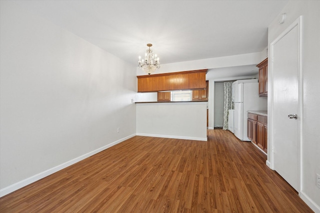 14333 Memorial Dr Unit 72, Houston, TX 77079 - unfurnished living room featuring a chandelier, baseboards, and dark wood-style floors