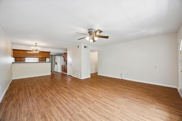14333 Memorial Dr Unit 72, Houston, TX 77079 - unfurnished living room featuring a chandelier, ceiling fan, light wood-style floors, and baseboards