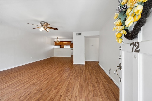 14333 Memorial Dr Unit 72, Houston, TX 77079 - unfurnished living room featuring wood finished floors, a ceiling fan, a chandelier, and baseboards