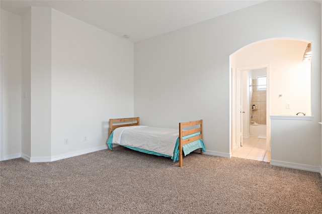 19406 Egret Haven Ln, Cypress, TX 77433 - bedroom featuring arched walkways, carpet, connected bathroom, and baseboards