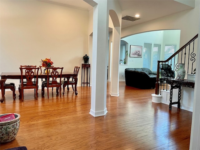 19406 Egret Haven Ln, Cypress, TX 77433 - dining room featuring arched walkways, wood finished floors, baseboards, and stairway