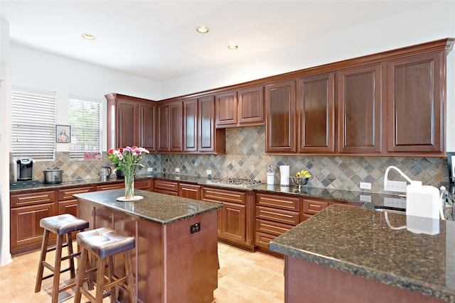 19406 Egret Haven Ln, Cypress, TX 77433 - kitchen featuring stainless steel gas cooktop, light tile patterned floors, a center island, backsplash, and recessed lighting