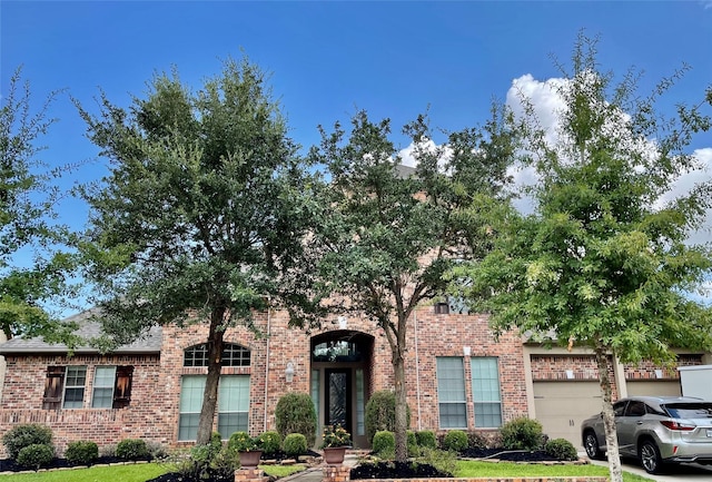 19406 Egret Haven Ln, Cypress, TX 77433 - view of property hidden behind natural elements featuring brick siding and a garage