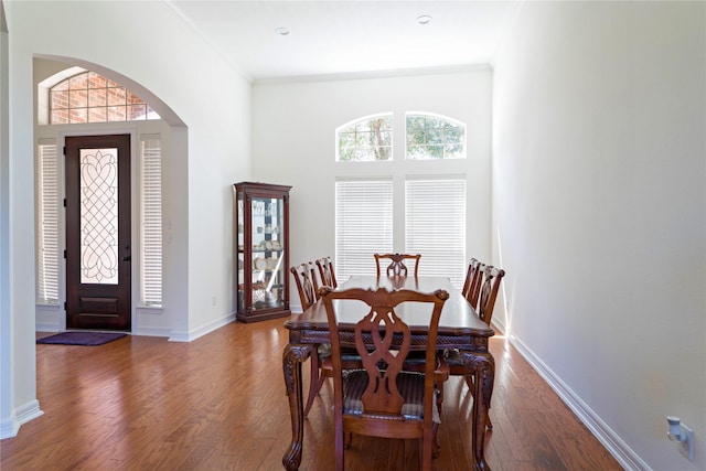 19406 Egret Haven Ln, Cypress, TX 77433 - dining area featuring wood finished floors, arched walkways, baseboards, and crown molding