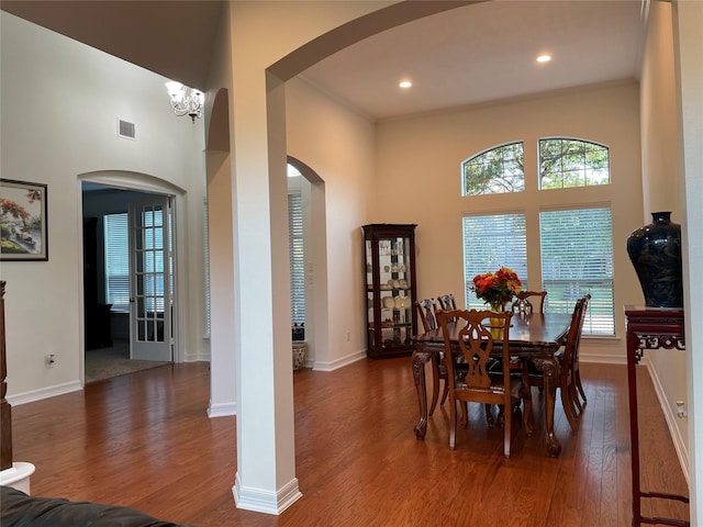 19406 Egret Haven Ln, Cypress, TX 77433 - dining room with a high ceiling, arched walkways, wood finished floors, healthy amount of natural light, and baseboards