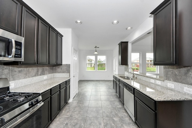 3727 Varna Ct, Missouri City, TX 77459 - kitchen featuring stainless steel appliances, a sink, light stone counters, backsplash, and recessed lighting
