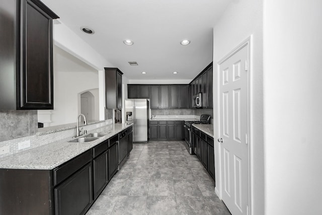 3727 Varna Ct, Missouri City, TX 77459 - kitchen with appliances with stainless steel finishes, a sink, arched walkways, tasteful backsplash, and recessed lighting