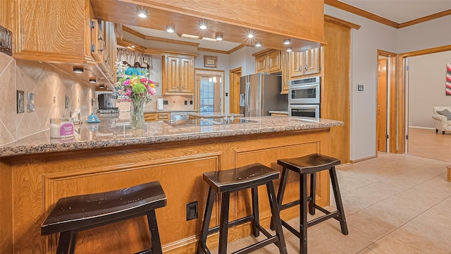 1806 Wine Cedar Ln, Katy, TX 77450 - kitchen featuring stainless steel appliances, ornamental molding, a peninsula, light tile patterned floors, and light stone counters