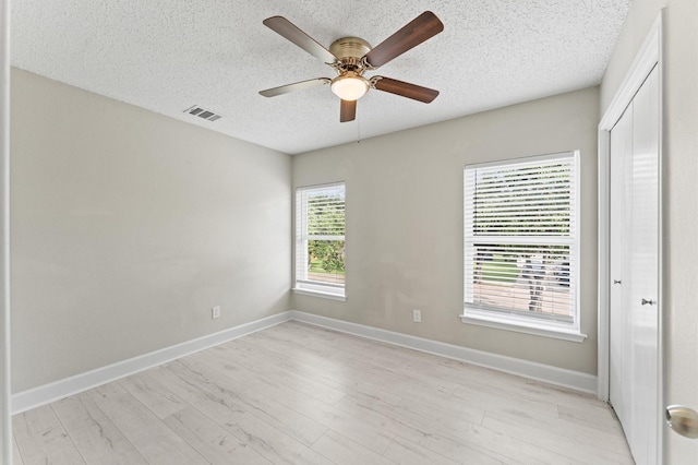 4519 Pioneer Trl, Sugar Land, TX 77479 - unfurnished bedroom with a textured ceiling, light wood finished floors, a closet, baseboards, and ceiling fan