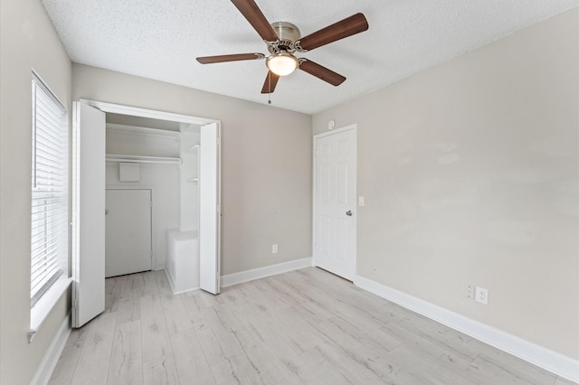 4519 Pioneer Trl, Sugar Land, TX 77479 - unfurnished bedroom featuring light wood-style flooring, a textured ceiling, baseboards, ceiling fan, and a closet