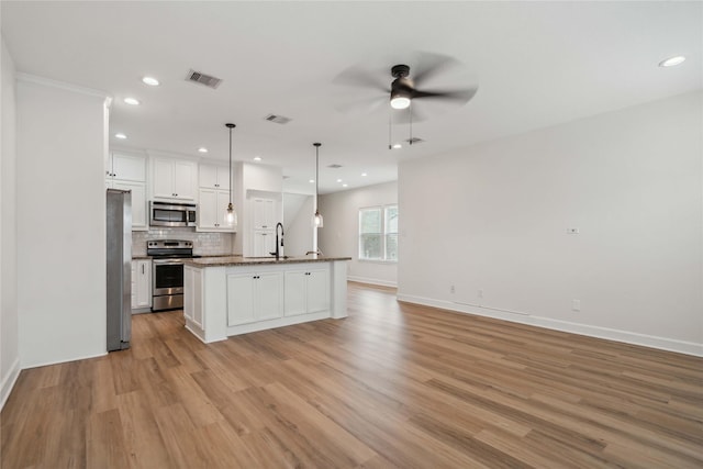 5402 Jonathan Ln, Houston, TX 77011 - kitchen with appliances with stainless steel finishes, light wood-style floors, ceiling fan, white cabinetry, and open floor plan
