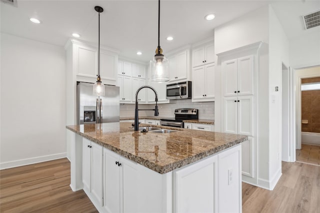 5402 Jonathan Ln, Houston, TX 77011 - kitchen featuring appliances with stainless steel finishes, baseboards, white cabinetry, and recessed lighting