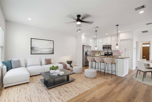 5402 Jonathan Ln, Houston, TX 77011 - living area with a ceiling fan, light wood-style flooring, and recessed lighting