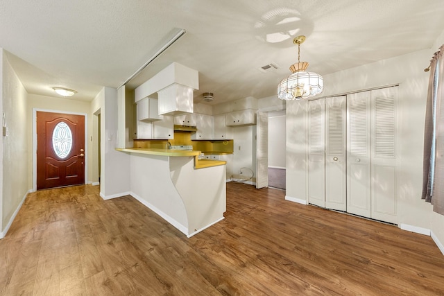 7306 Nightingale Cir, Texas City, TX 77591 - kitchen with a peninsula, wood finished floors, baseboards, and a chandelier