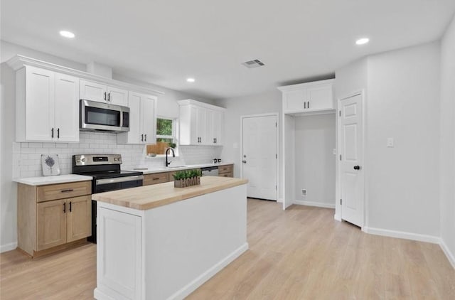 2811 Winbern St, Houston, TX 77004 - kitchen with stainless steel appliances, decorative backsplash, light wood-type flooring, baseboards, and recessed lighting