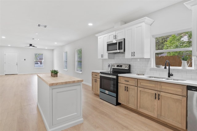 2811 Winbern St, Houston, TX 77004 - kitchen with stainless steel appliances, a sink, butcher block countertops, decorative backsplash, and a center island