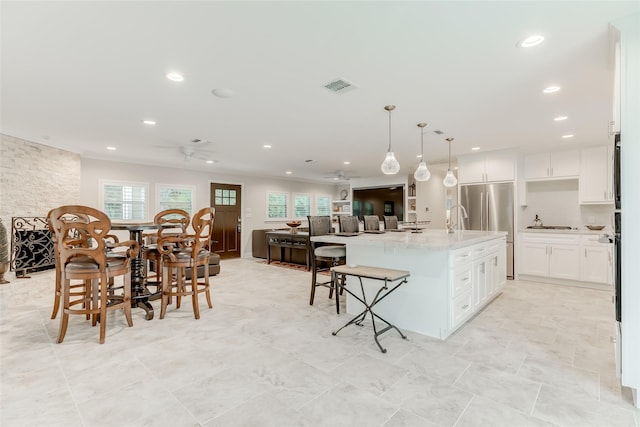 14001/14009 W Hughes Rd, Dickinson, TX 77539 - kitchen with a ceiling fan, freestanding refrigerator, recessed lighting, a kitchen island with sink, and white cabinets