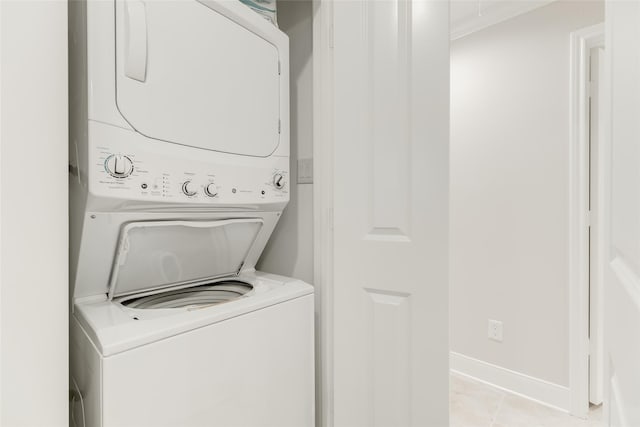 14001/14009 W Hughes Rd, Dickinson, TX 77539 - laundry room with stacked washer and clothes dryer, light tile patterned floors, and baseboards