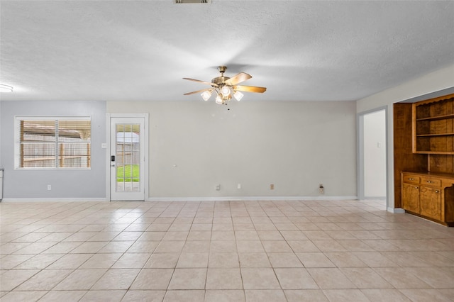 1102 Brenda Dr, Deer Park, TX 77536 - unfurnished living room featuring a textured ceiling, a ceiling fan, light tile patterned flooring, and baseboards