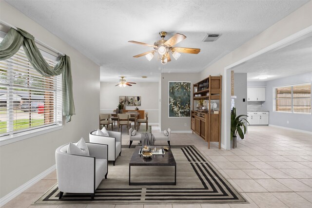 1102 Brenda Dr, Deer Park, TX 77536 - living room with a ceiling fan, light tile patterned floors, baseboards, and a textured ceiling