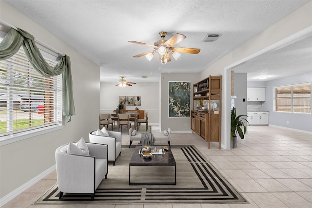 1102 Brenda Dr, Deer Park, TX 77536 - living area with a ceiling fan, light tile patterned floors, baseboards, and a textured ceiling